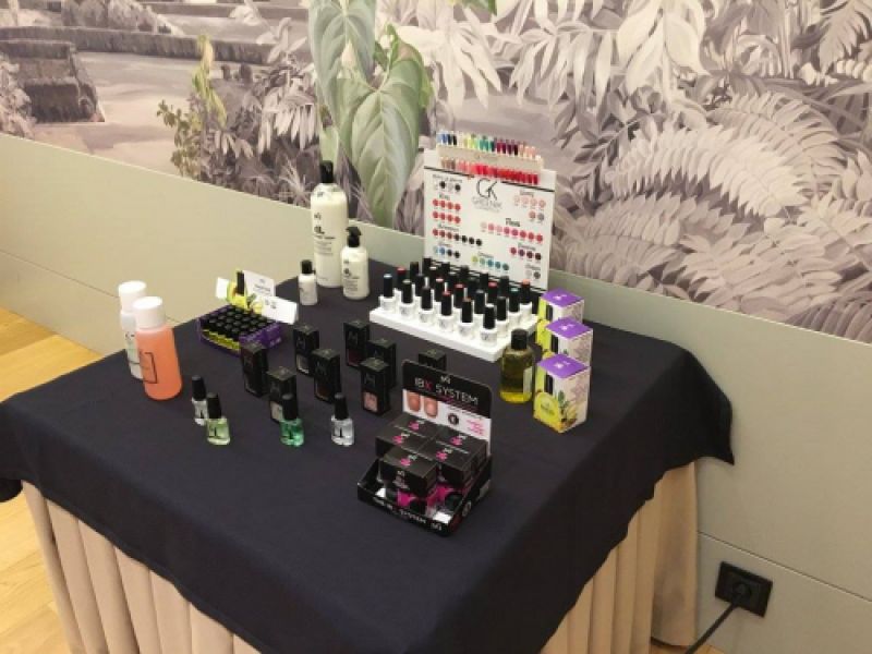 Muestrario de productos de estética expuestos en una mesa de una feria en un hotel