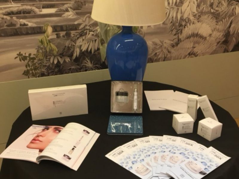 Muestrario de productos de estética expuestos en una mesa de una feria en un hotel