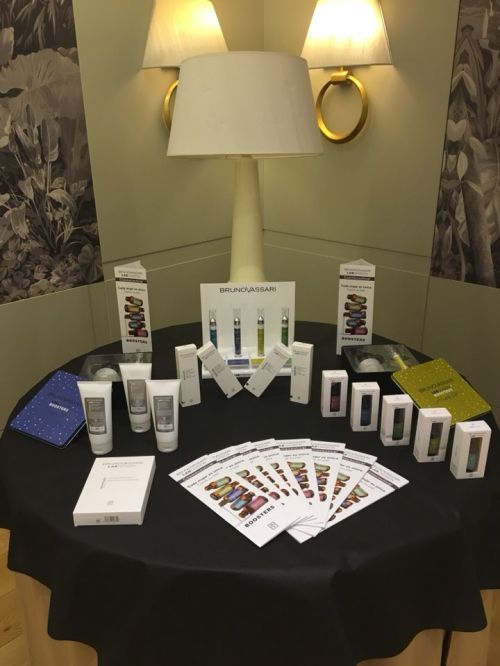 Muestrario de productos de estética expuestos en una mesa de una feria en un hotel